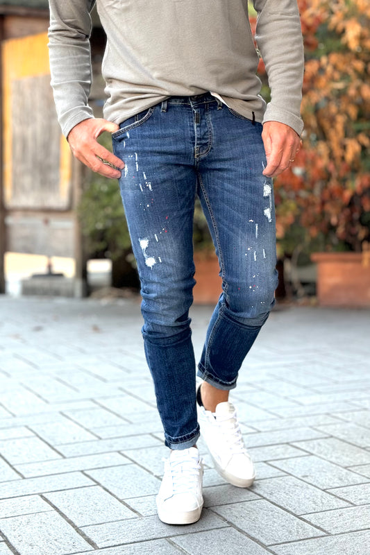 En Avance CK07 jeans lavaggio blu medio con abrasioni e micro splash di vernice